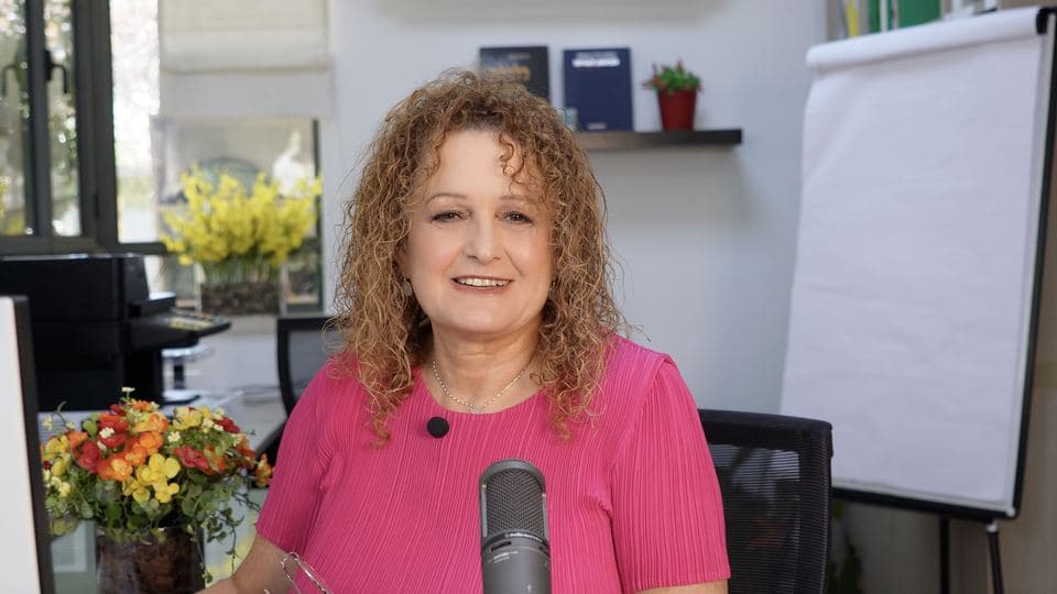 מרצה יושבת ליד לוח: פריים מקורס דיגיטלי
